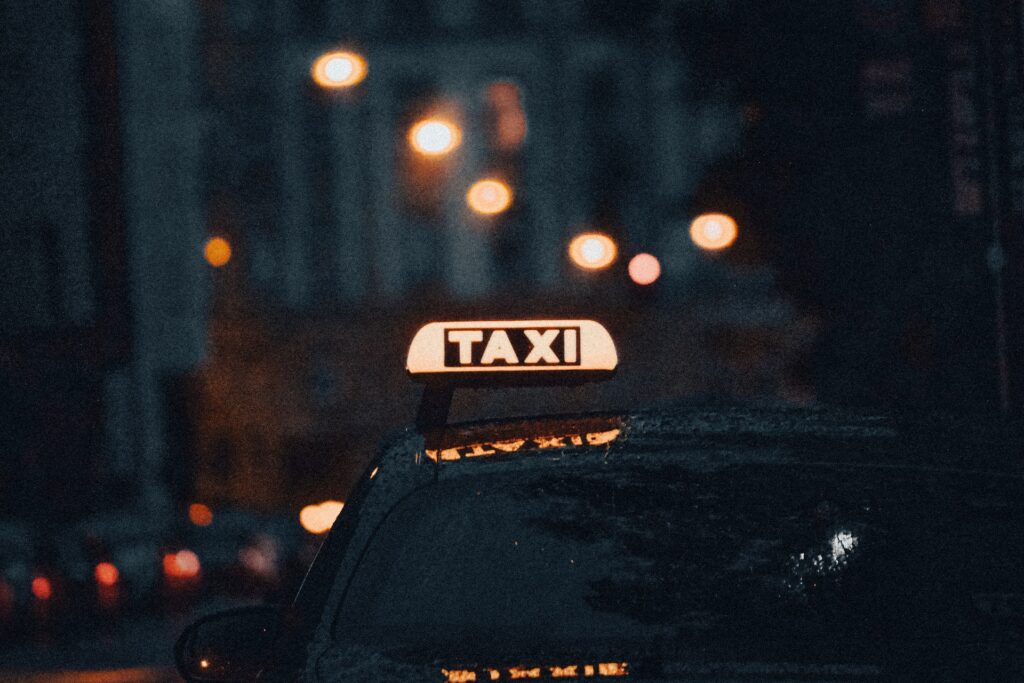 Soft focus of a taxi cab, with the illuminated sign atop of it in focus.