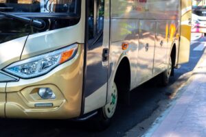 A close-up of a transport bus parked next to the curb.