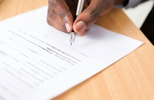 A hand signing a contract.